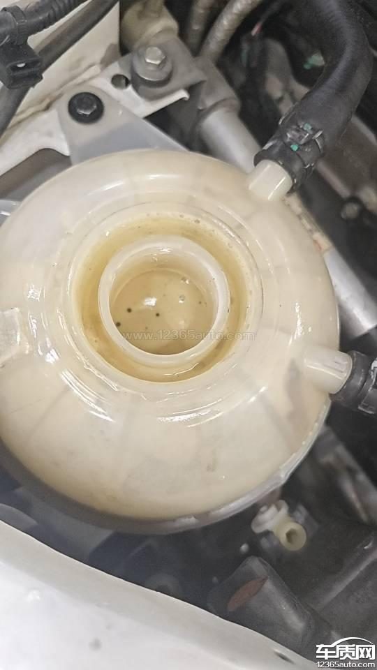 一张汽车维修车间内，一辆瑞虎8被举升机升起，底盘和发动机舱被拆解，工人正在检查的图片，用于表现维修过程的复杂和车主的无奈