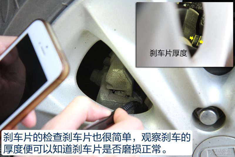 手电筒照射车底，显示发动机油底壳和排气管，底盘护板有轻微刮擦痕迹，没有明显漏油